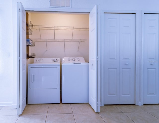 washroom with separate washer and dryer and light tile patterned floors