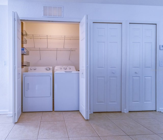 washroom featuring light tile patterned flooring and washing machine and clothes dryer