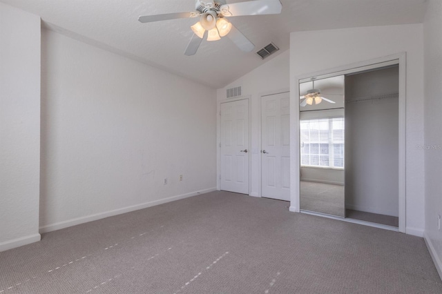 unfurnished bedroom with lofted ceiling, carpet flooring, ceiling fan, and a closet