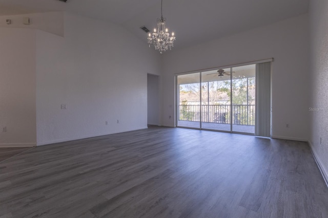 empty room with dark hardwood / wood-style flooring, high vaulted ceiling, and a chandelier