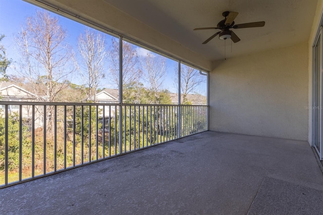 unfurnished sunroom with ceiling fan