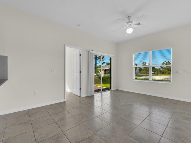 tiled spare room with ceiling fan