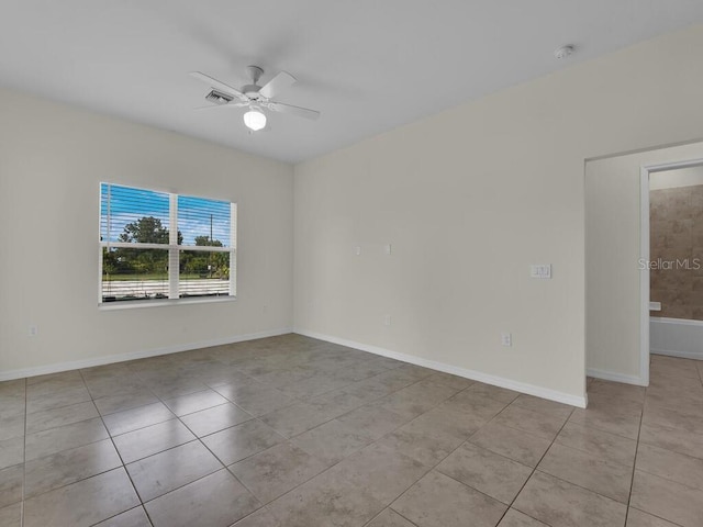 tiled spare room with ceiling fan