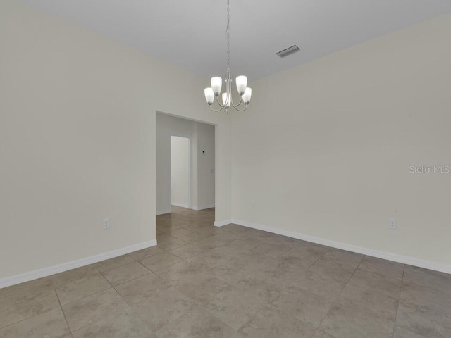 spare room featuring an inviting chandelier