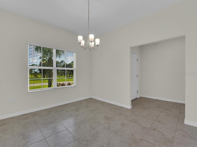 empty room with a notable chandelier and light tile patterned floors