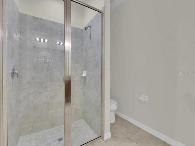 bathroom featuring a shower with door, tile patterned floors, and toilet