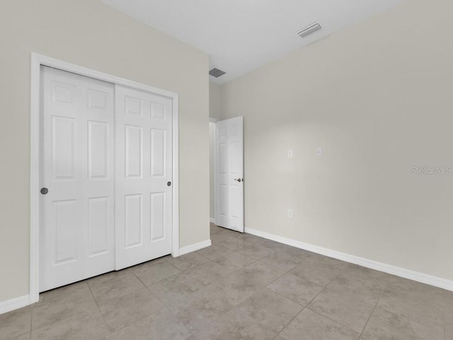 unfurnished bedroom with a closet and light tile patterned flooring