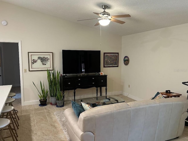 living room featuring vaulted ceiling, ceiling fan, and a textured ceiling