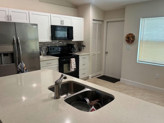 kitchen featuring sink, backsplash, white cabinetry, and black appliances