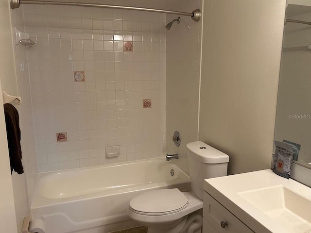 full bathroom featuring tiled shower / bath, vanity, and toilet