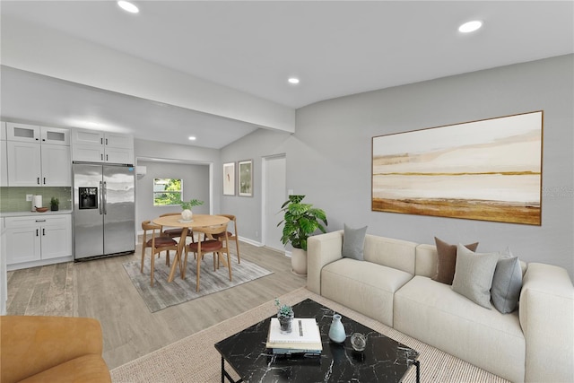 living room featuring vaulted ceiling and light hardwood / wood-style flooring