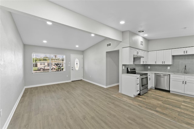 kitchen with tasteful backsplash, sink, white cabinetry, appliances with stainless steel finishes, and hardwood / wood-style floors