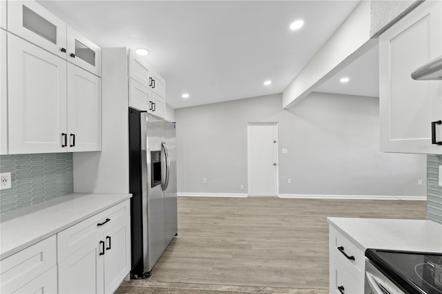 kitchen with light hardwood / wood-style flooring, white cabinets, stainless steel fridge with ice dispenser, and tasteful backsplash