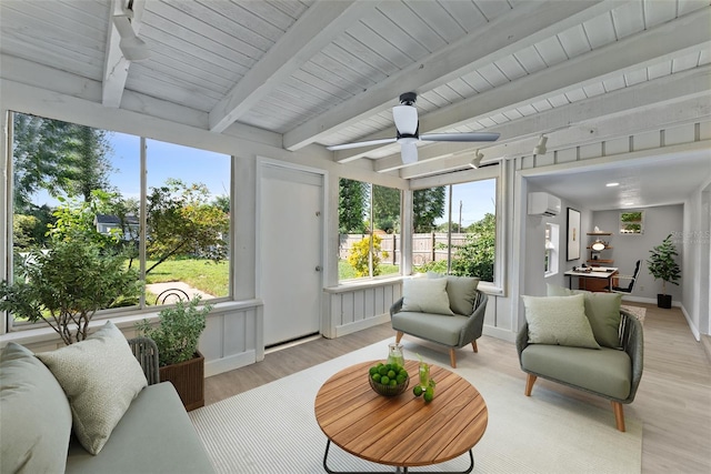 sunroom / solarium with a healthy amount of sunlight, beam ceiling, an AC wall unit, and ceiling fan