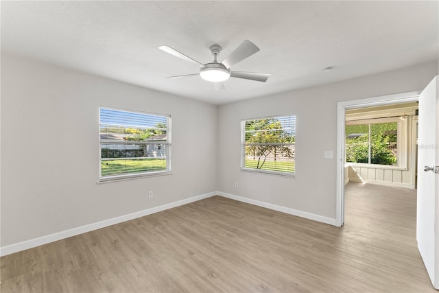 empty room with a textured ceiling, light hardwood / wood-style floors, and ceiling fan