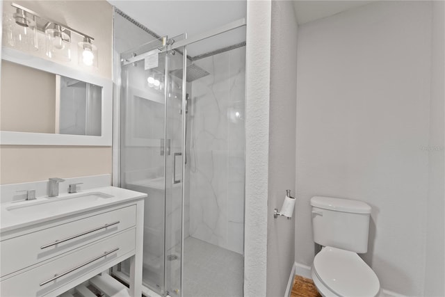 bathroom with a shower with door, toilet, and vanity