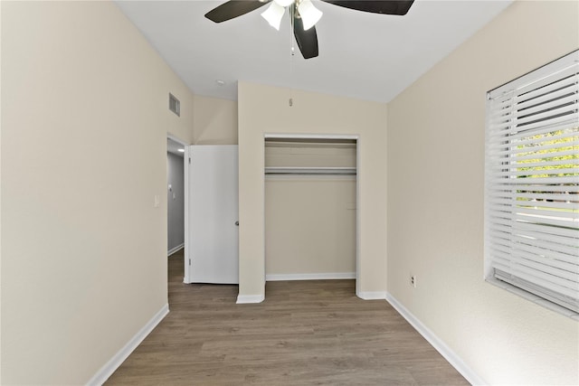 unfurnished bedroom with light hardwood / wood-style flooring, a closet, vaulted ceiling, and ceiling fan