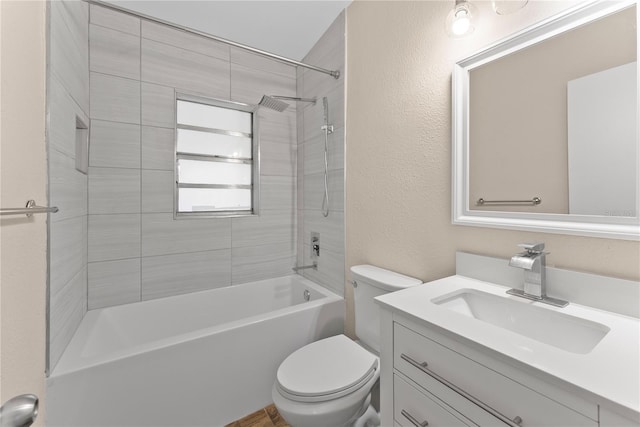 full bathroom with tiled shower / bath, vanity, and toilet