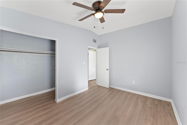 unfurnished bedroom with light hardwood / wood-style flooring, a closet, vaulted ceiling, and ceiling fan