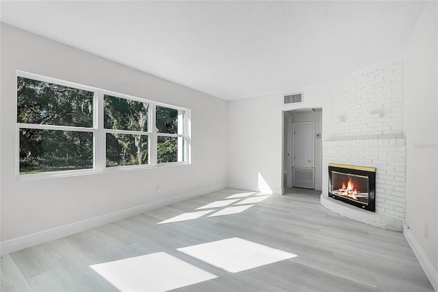 unfurnished living room with a fireplace and light hardwood / wood-style flooring