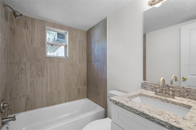 full bathroom with a textured ceiling, vanity, tiled shower / bath combo, and toilet