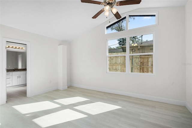 unfurnished room with sink, ceiling fan, light hardwood / wood-style flooring, and high vaulted ceiling