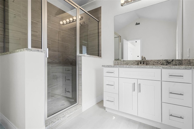 bathroom with lofted ceiling, walk in shower, and vanity