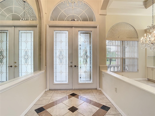 entrance foyer featuring french doors, crown molding, a notable chandelier, and light tile patterned floors