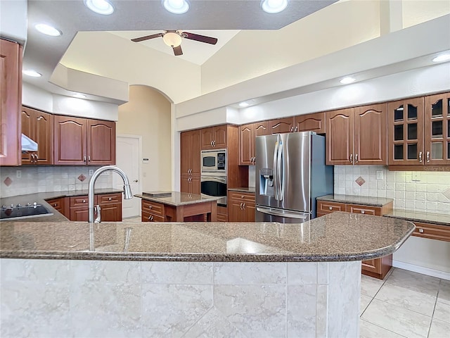 kitchen with appliances with stainless steel finishes, vaulted ceiling, decorative backsplash, and a kitchen island