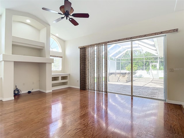 unfurnished living room featuring vaulted ceiling, hardwood / wood-style flooring, and ceiling fan