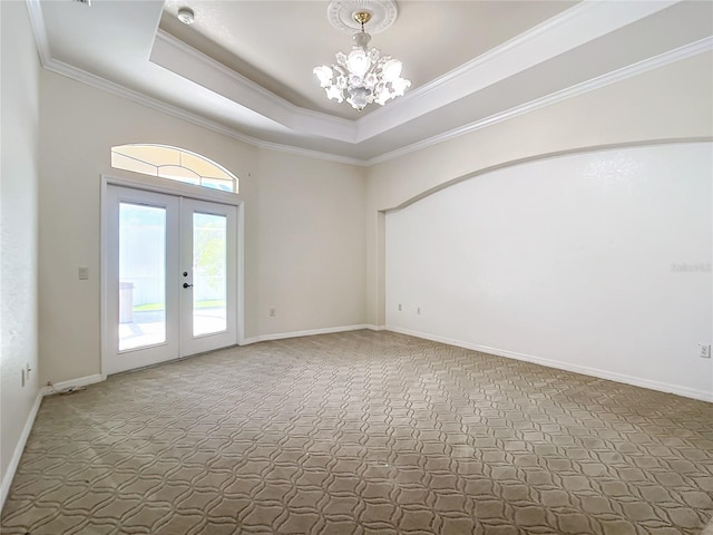 empty room featuring dark carpet, a raised ceiling, french doors, an inviting chandelier, and crown molding