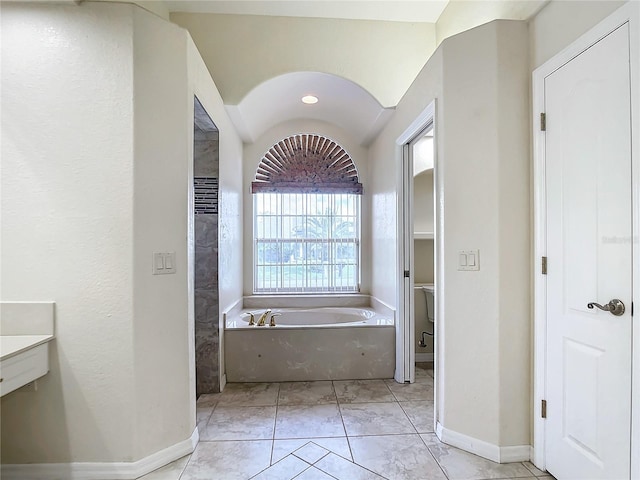 bathroom featuring a bathtub, tile patterned floors, and toilet