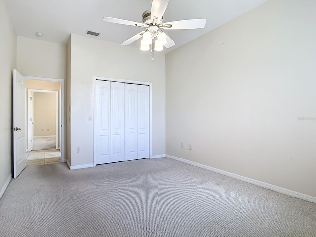 unfurnished bedroom featuring a closet, ceiling fan, and light carpet