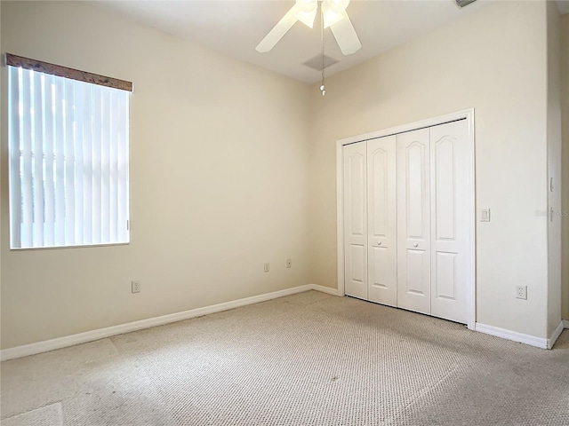 unfurnished bedroom featuring ceiling fan, light colored carpet, and a closet