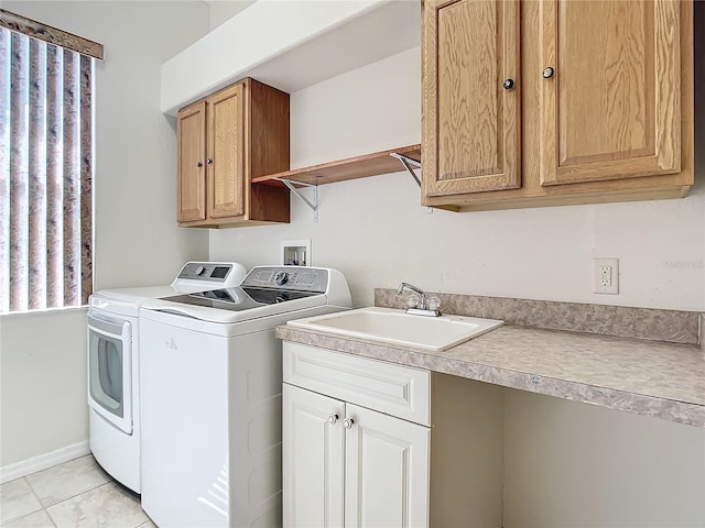 clothes washing area with cabinets, sink, and washer and clothes dryer