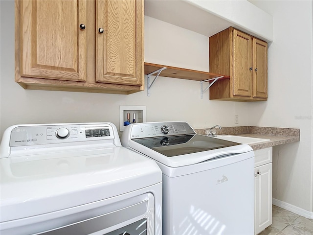 laundry area featuring washing machine and dryer, sink, and cabinets