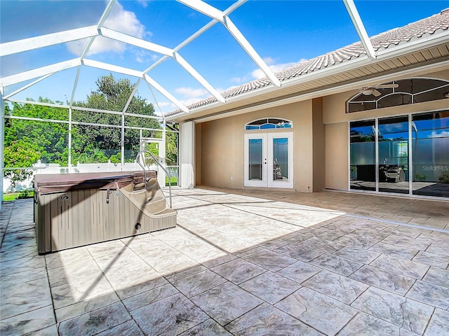 view of patio / terrace featuring glass enclosure, a hot tub, and french doors