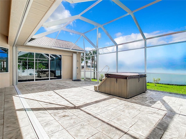 view of patio featuring a lanai and a hot tub