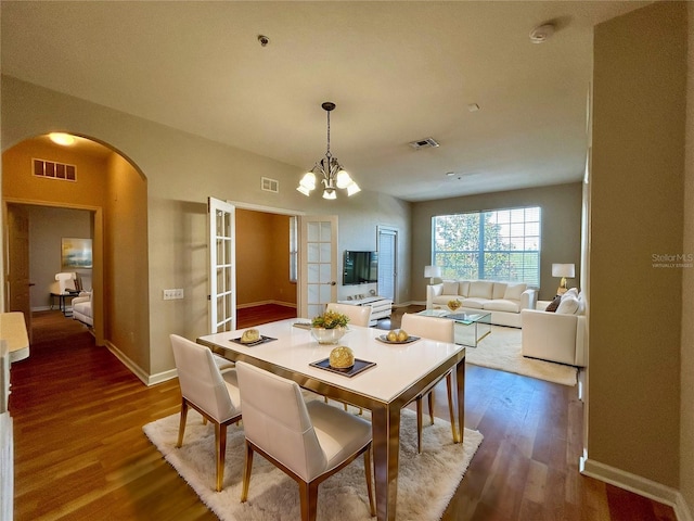 dining area with wood-type flooring and a chandelier