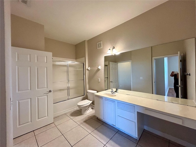 full bathroom with tile patterned flooring, bath / shower combo with glass door, vanity, and toilet