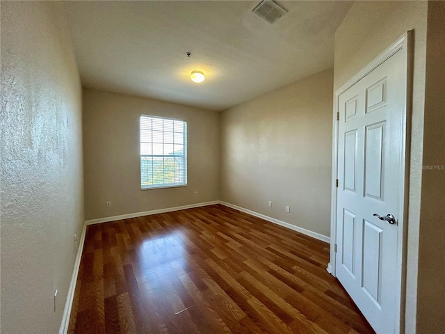 empty room with dark wood-type flooring