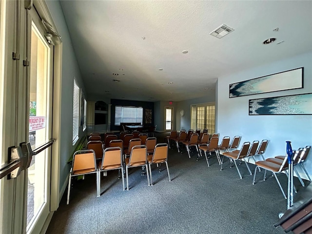 dining area featuring a textured ceiling and carpet