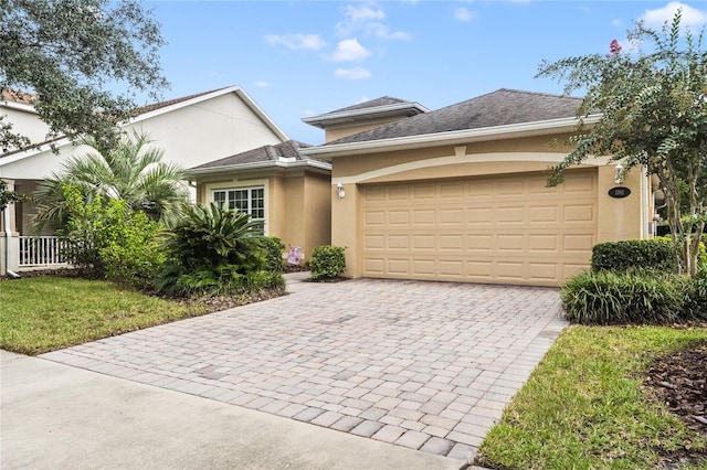 view of front of property with stucco siding, a garage, and decorative driveway