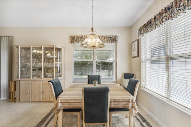 dining space with a chandelier, plenty of natural light, and light tile patterned flooring