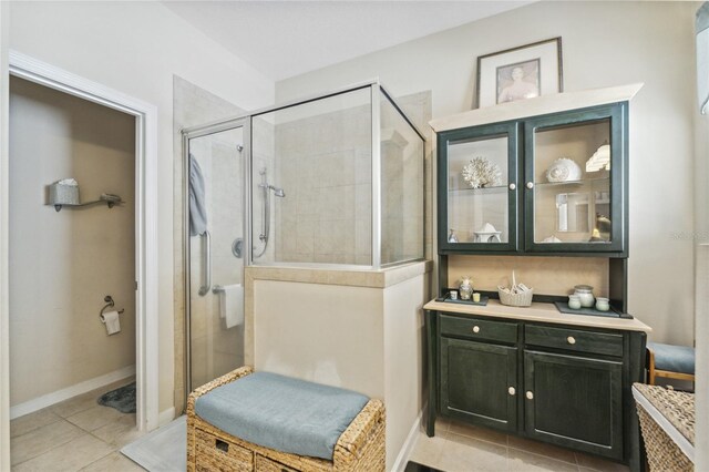 bathroom featuring walk in shower, vanity, and tile patterned flooring