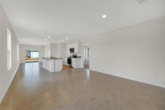 unfurnished living room with sink and light tile patterned floors