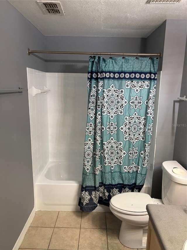 full bathroom featuring tile patterned floors, shower / bath combo, toilet, vanity, and a textured ceiling