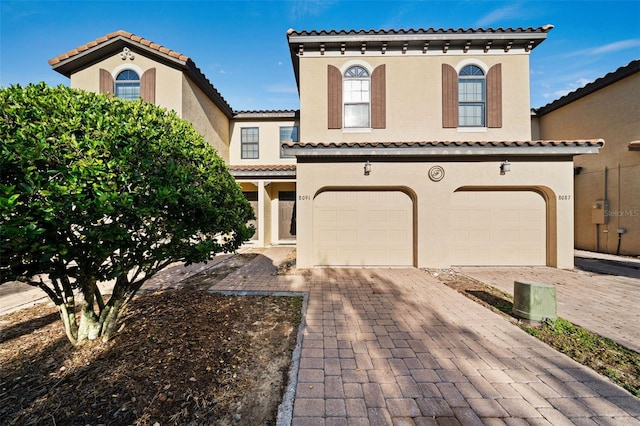 8091 Brooksville Dr, Davenport, FL 33896 - mediterranean / spanish-style house with stucco siding, an attached garage, and a tiled roof