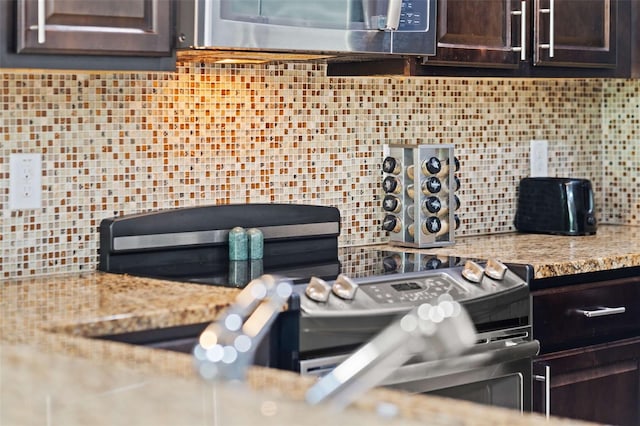 kitchen with light stone counters, tasteful backsplash, and dark brown cabinetry