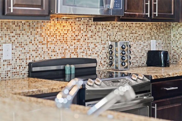 8091 Brooksville Dr, Davenport, FL 33896 - kitchen view of stainless steel microwave, dark brown cabinets, and tasteful backsplash